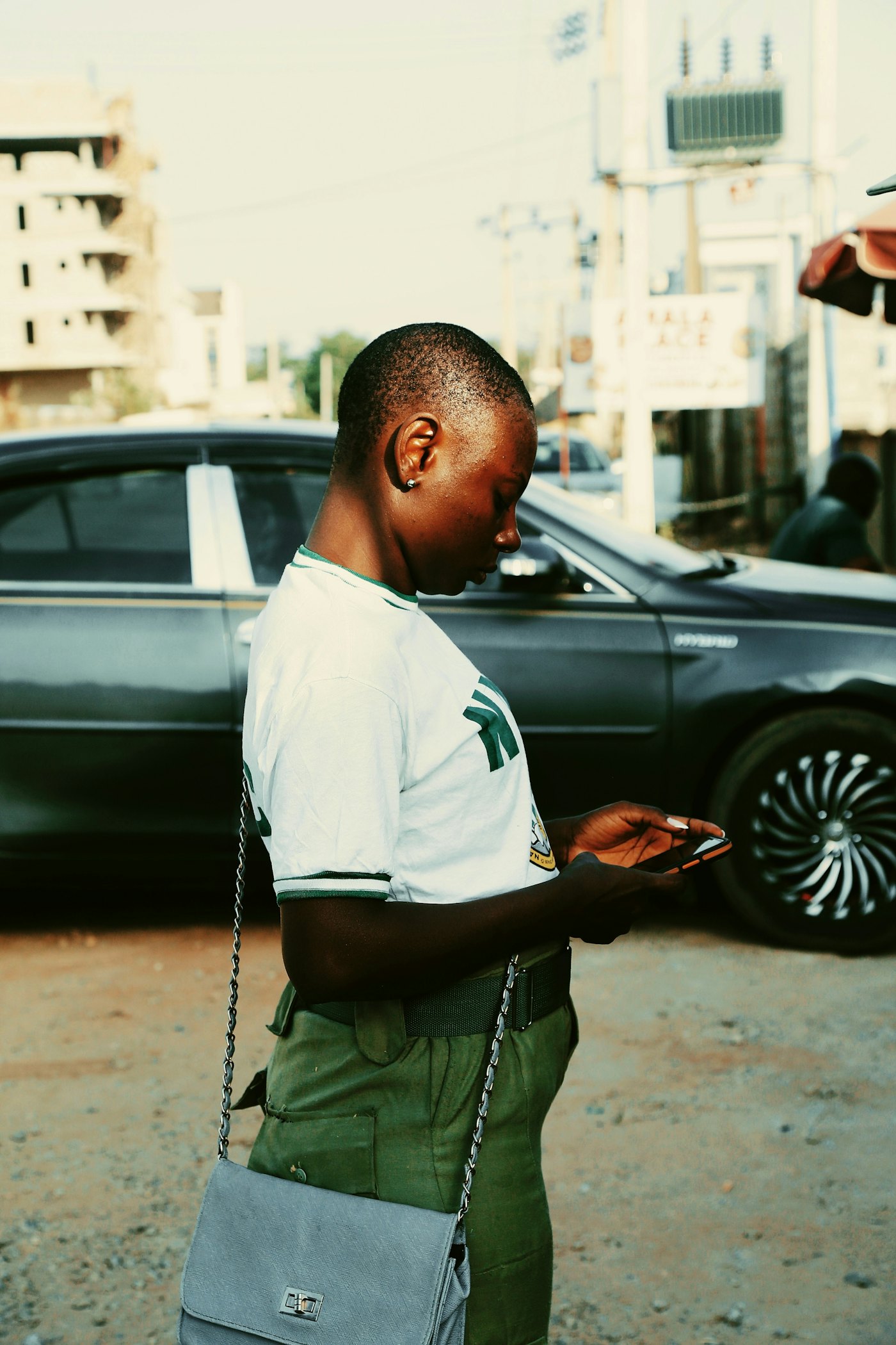 A young woman checking her phone on a busy street